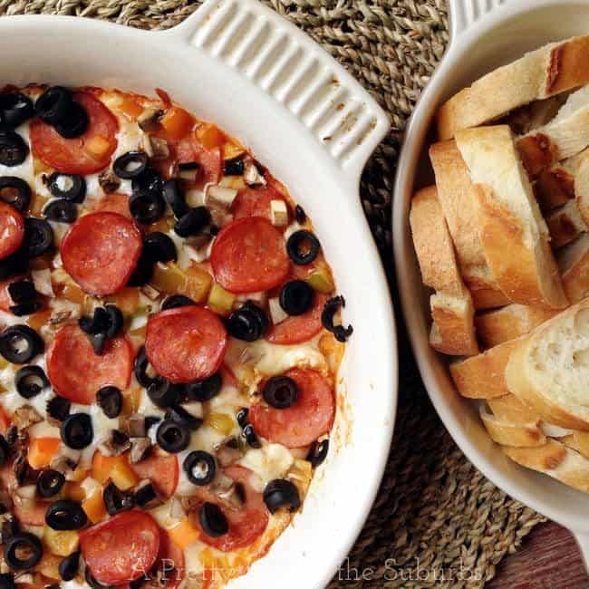 Creamy and Cheesy Hot Pizza Dip in a White Casserole, Sliced bread loaf in another casserole