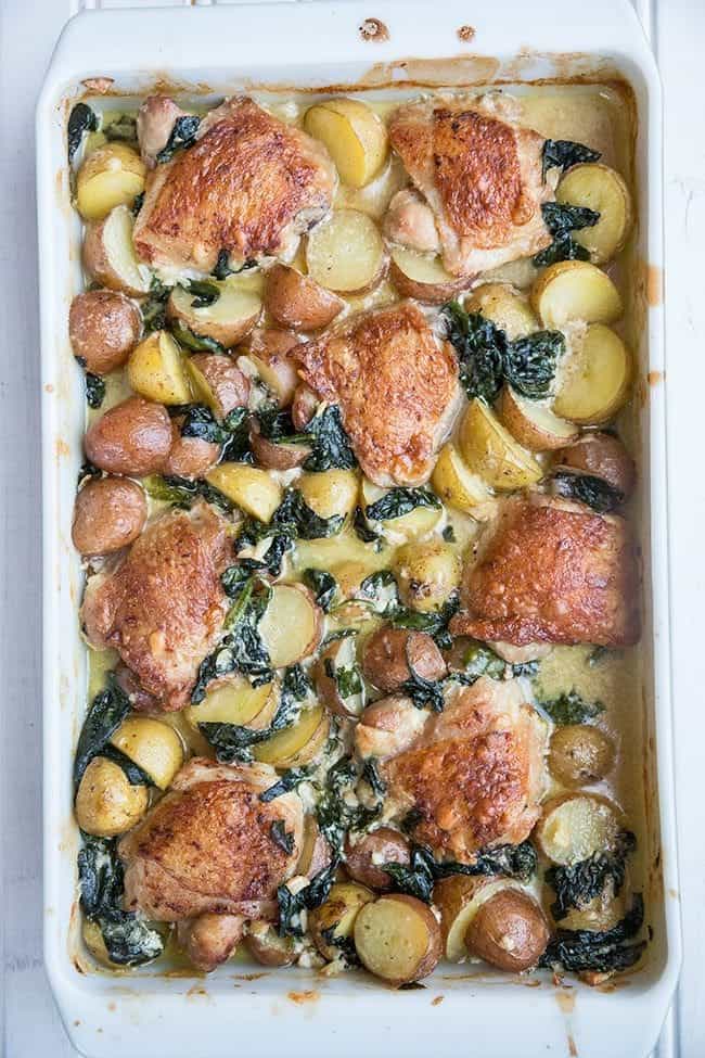 Top down shot of Creamy Garlic Parmesan Chicken & Potatoes in a White Baking Pan