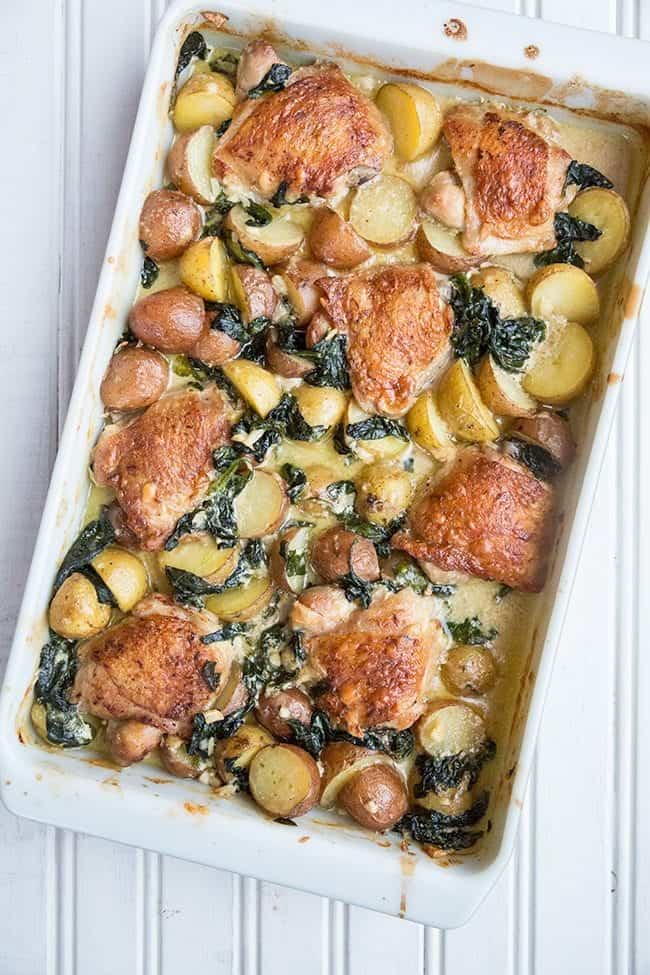 Top down shot of Creamy Garlic Parmesan Chicken & Potatoes in a White Baking Pan