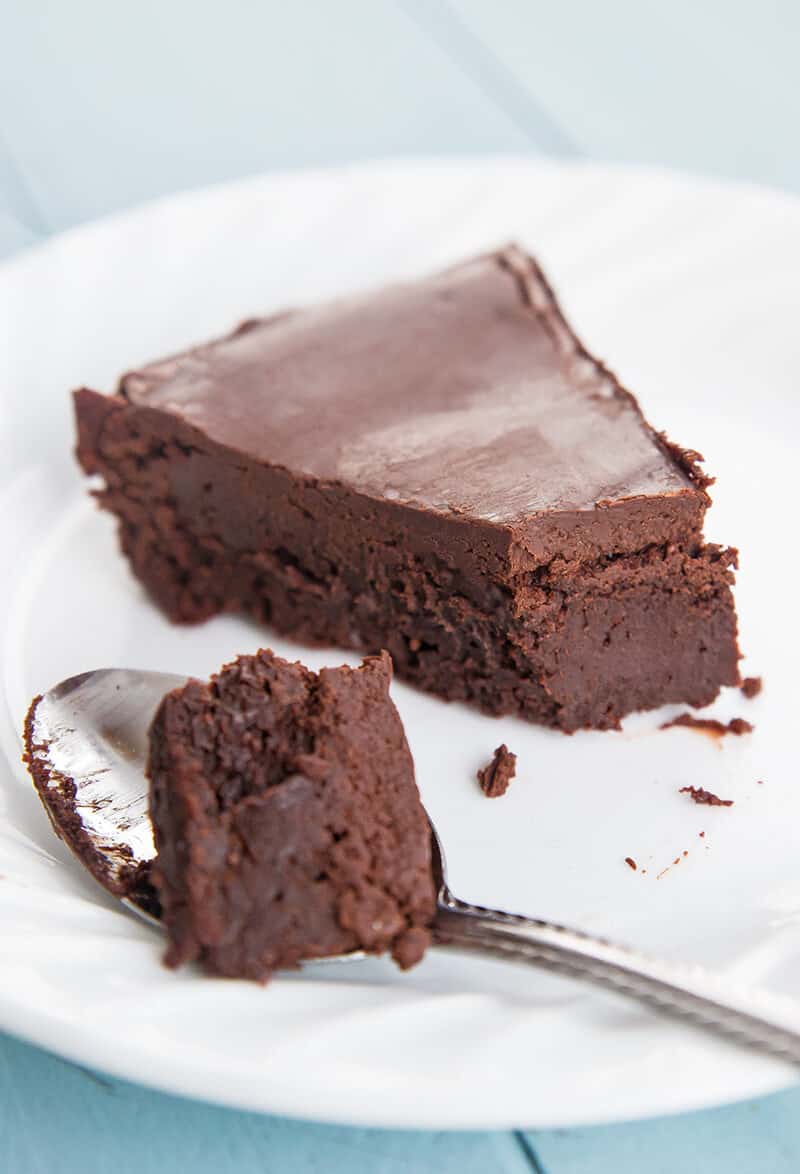 close up slice of Flourless Chocolate Cake in a white plate