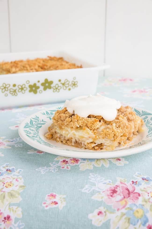 Pineapple Soda Cracker Dessert served with dollop of whipped cream on top in a plate and in a baking dish at the back