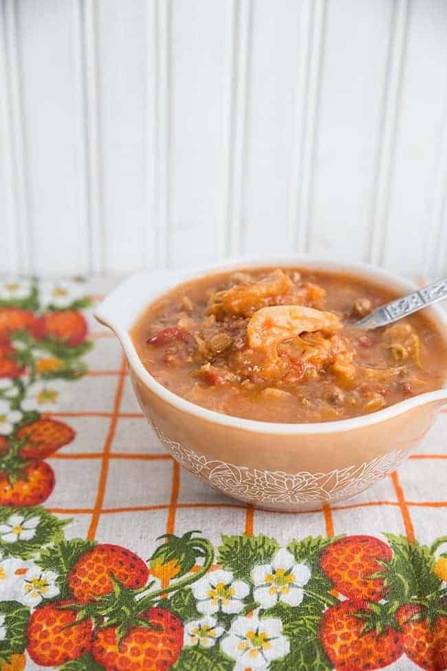 Cabbage Roll Soup in a Pyrex bowl, a floral vintage tablecloth underneath and white background