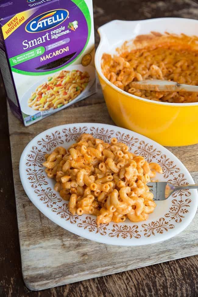 Sneaky Vegetable Mac n’ Cheese in a Pyrex Colored Casserole and in White Plate with a Fork in it