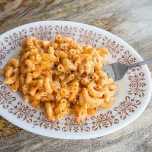 Sneaky Vegetable Mac n’ Cheese in a White Plate with a Fork in it on wood background