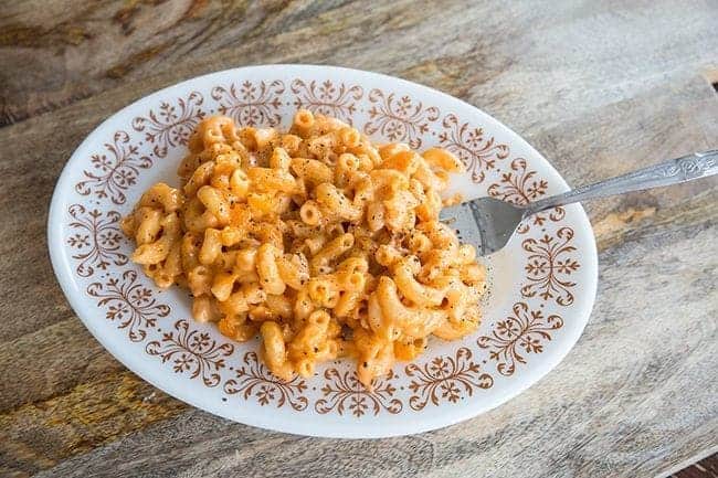 Sneaky Vegetable Mac n’ Cheese in a White Plate with a Fork in it on wood background