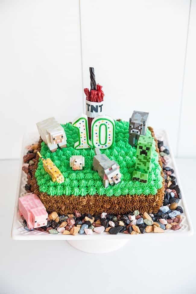 close up of Minecraft Birthday Party Cake with Buttercream Icing, Minecraft plastic figurines and some chocolate rocks randomly around