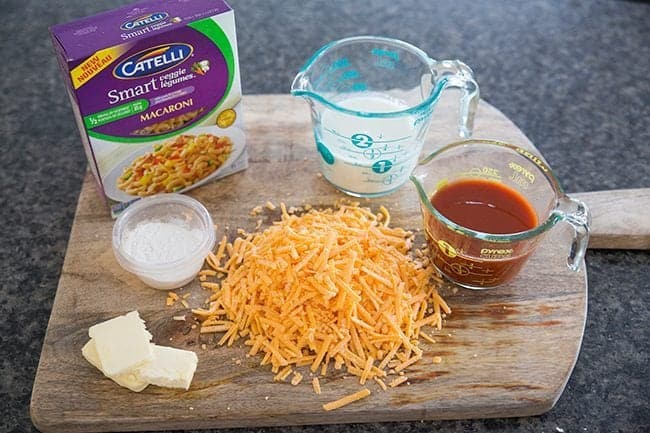 Ingredients needed in making Sneaky Vegetable Mac n’ Cheese all in wooden board