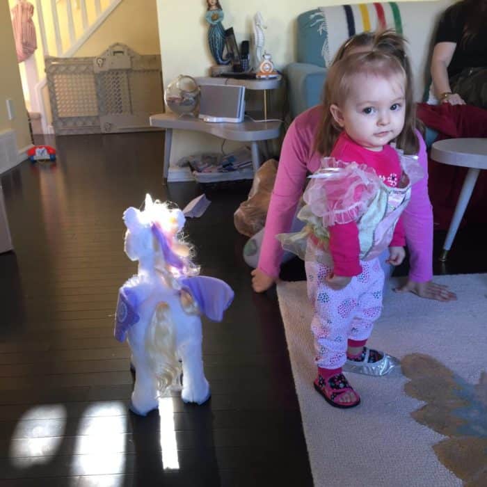 toddler standing in the carpet wearing one silver shoe