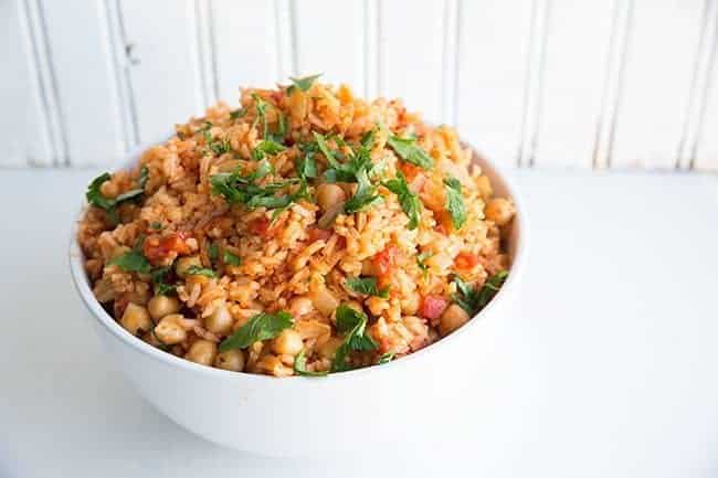 Smoky Spanish Rice & Chickpeas Topped with Chopped Parsley on White Bowl