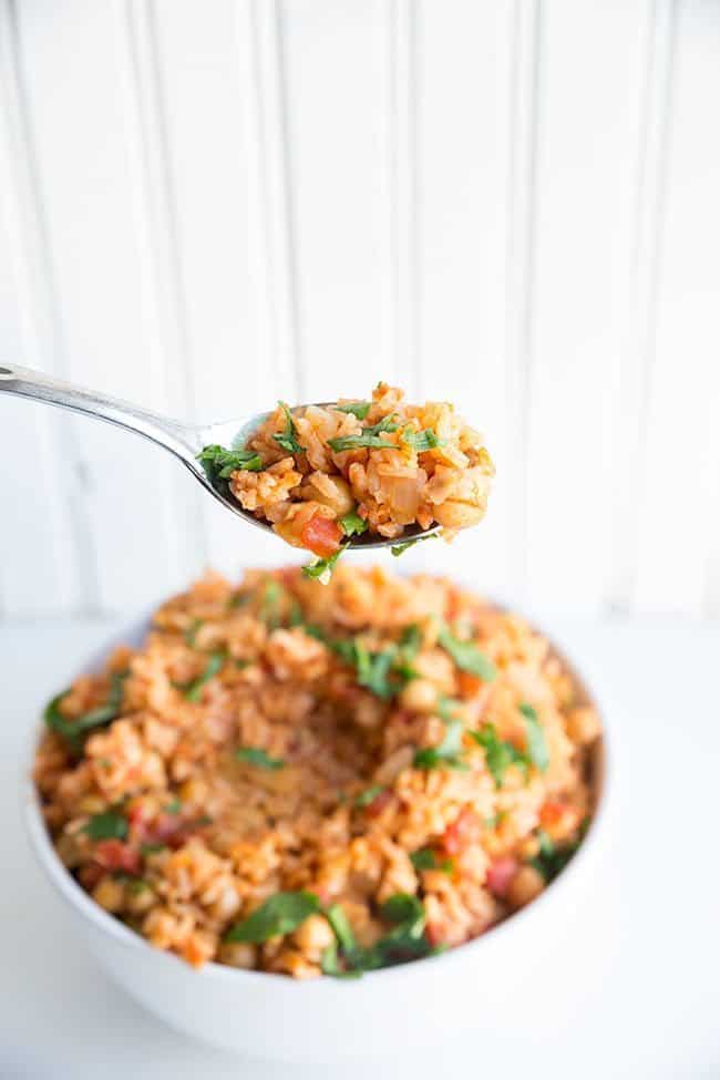 Spoon of Vegan Smoky Spanish Rice & Chickpeas on white background