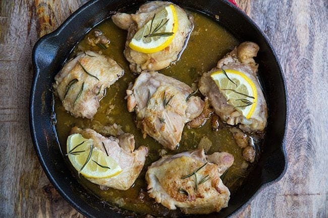 Rosemary Lemon Oven Baked Chicken Thighs on a red skillet