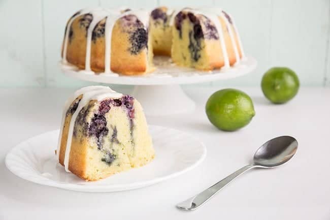  Blueberry Lime Bundt Cake on a white cake holder and in a small white plate