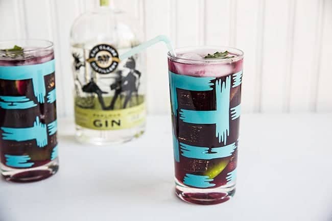 Blueberry Mint Gin Fizz garnish with mint leaf and a straw