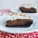 Slices of Chocolate Flapper Pie in white dessert plates over red tablecloth