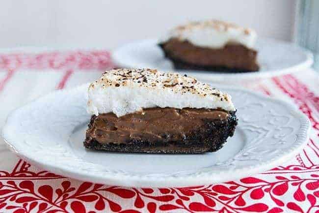 Slices of Chocolate Flapper Pie in white dessert plates over red tablecloth