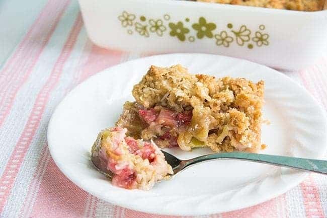 Coconut Rhubarb Crunch in a white plate and in a baking dish