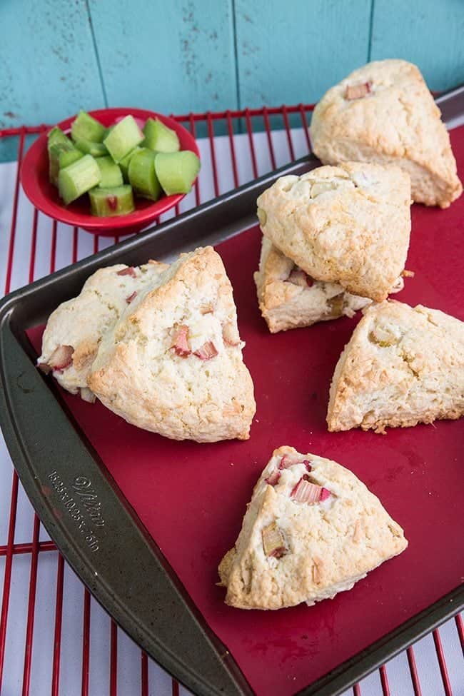  Close up of Coconut Rhubarb Scones on a red lined baking sheet