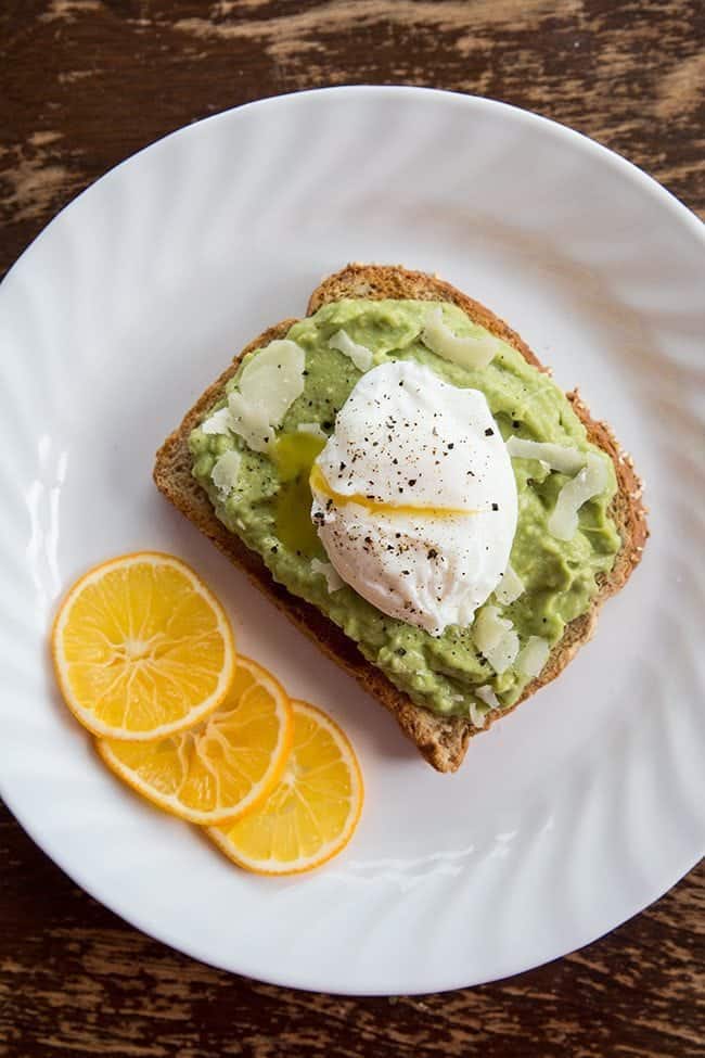 close up of Meyer Lemon Parmesan Avocado Toast & Egg in a white plate