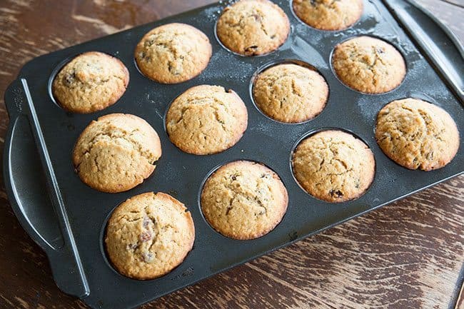 Oatmeal Raisin Muffins in muffin tins on wood background