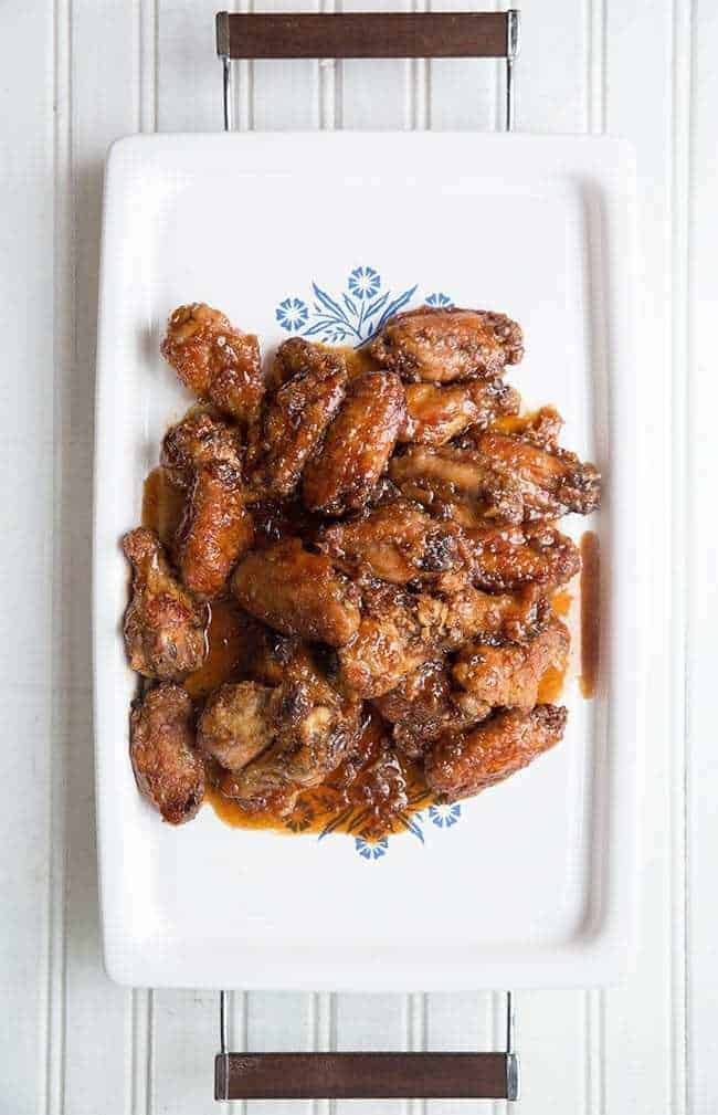 Saucy Japanese Chicken Wings in a white serving tray on white background