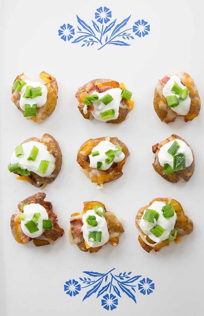 top down shot of Mini Loaded Smashed Potato Bites topped with sour cream, bacon, cheese and green onions