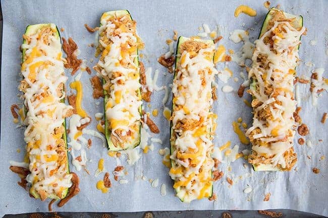 Cheesy Buffalo Chicken Zucchini Boats in a baking sheet with parchment paper