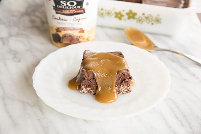 Frosty Vegan Chocolate Truffle Squares topped with caramel sauce and a tub of Cashewmilk Frozen Desserts