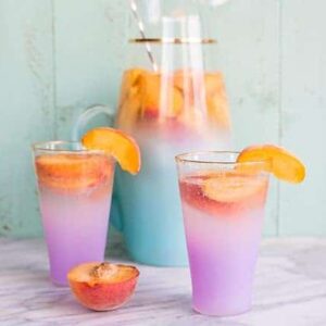 close up of Sparkling Peach Sangria garnish with a slices of fresh Peach