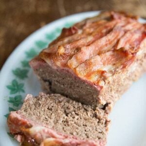 Top down shot of Sliced BaconMeatloaf in White Plate with Green Leaves Prints