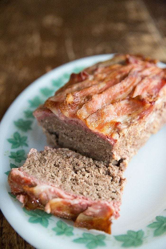 Top down shot of Sliced BaconMeatloaf in White Plate with Green Leaves Prints