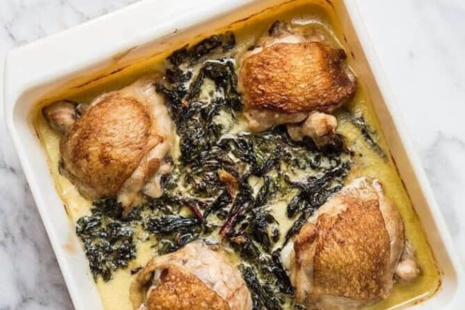 top down shot of baking dish with Creamy Garlic Swiss Chard Chicken on a marble background