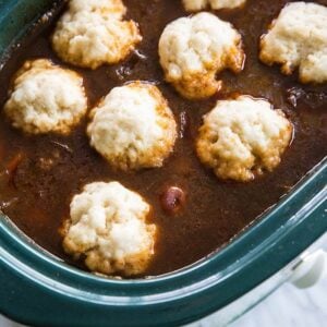 little dough dumplings on a crock pot full of soup