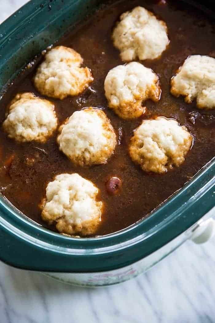 little dough dumplings on a crock pot full of soup