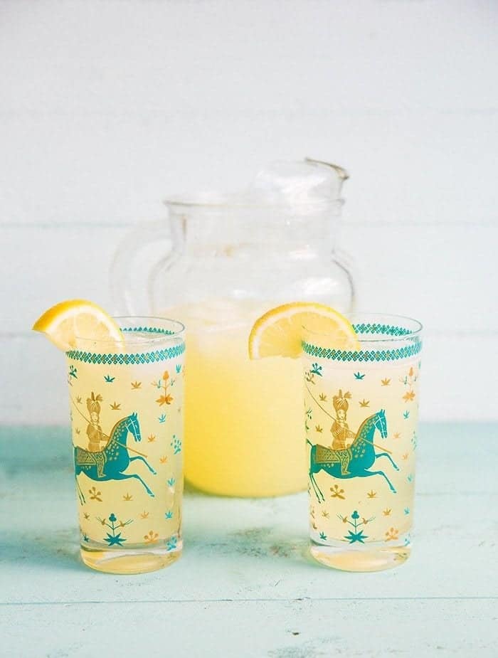 2 glasses of Sparkling Honey Bourbon Lemonade in glasses with Arabian design garnish with a slice of Lemon