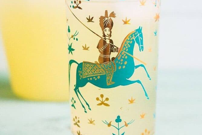 close up of Sparkling Honey Bourbon Lemonade in a glass with Arabian design garnish with a slice of Lemon