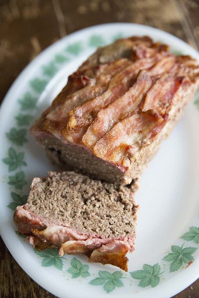 Top down shot of Sliced BaconMeatloaf in White Plate with Green Leaves Prints