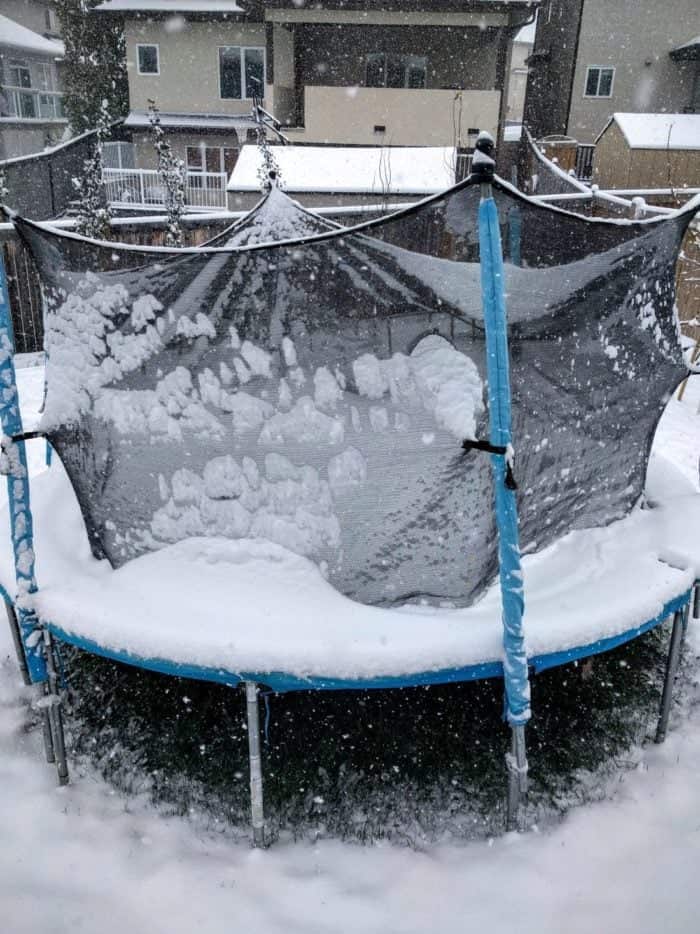 trampoline with snow in front of the houses