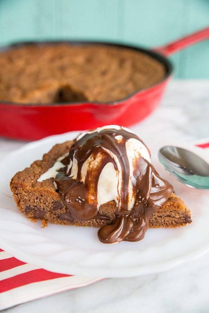 Reese's Chocolate Chip Skillet Cookie with ice cream melting and chocolate sauce on top