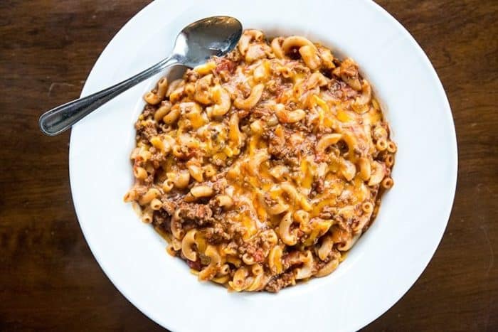 large white plate with Classic American Goulash and a spoon on side