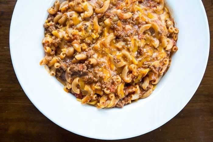 a large white plate with Classic American Goulash on wood background