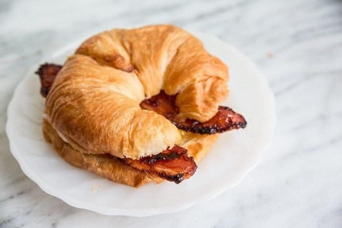 croissant slices with Air Fryer Bacon in a white plate 