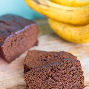 close up slices of Banana Gingerbread Loaf, ripe bananas on background