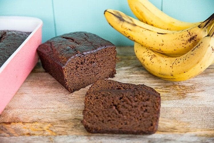 sliced Banana Gingerbread Loaf and ripe bananas on side