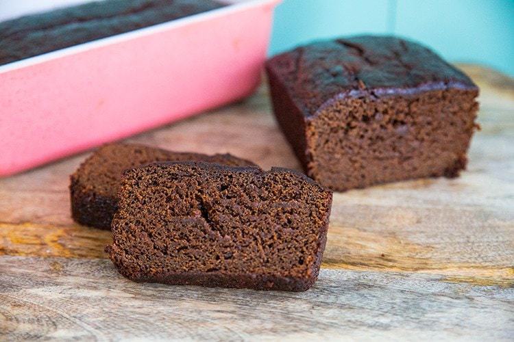 a Loaf of Banana Gingerbread sliced, pink loaf pan on background