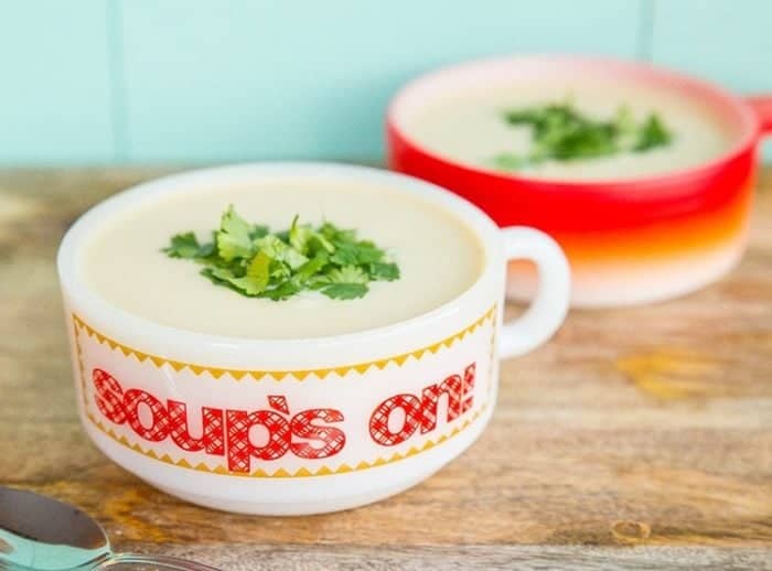 Potato Leek Soup in a red and white bowl with parsley garnish