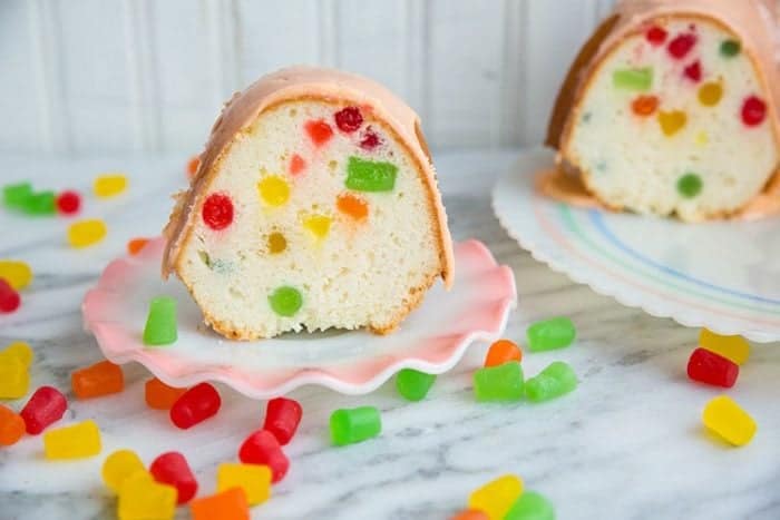 slices of glazed Gumdrop Cake in dessert plates, pieces of colorful gumdrops on the table