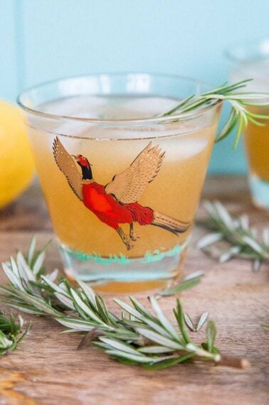 Maple Rosemary Bourbon Sour in a pheasant cocktail glasses with springs of rosemary