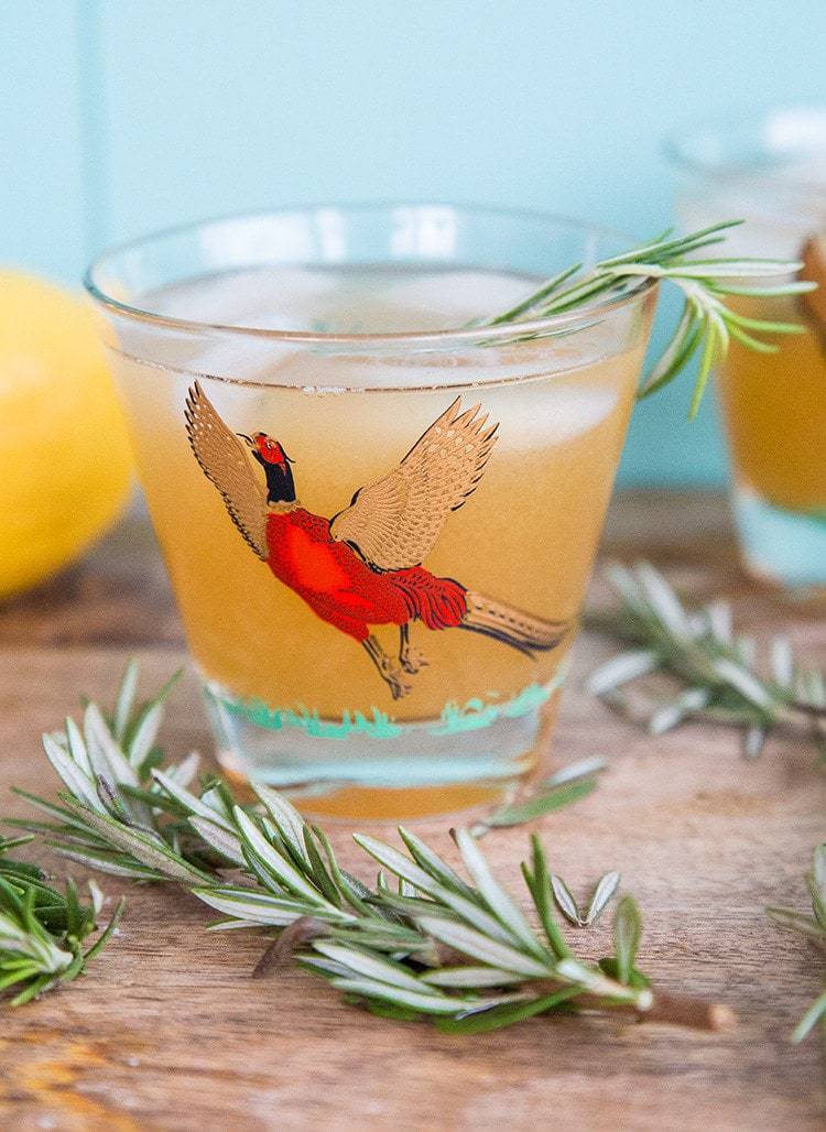 Maple Rosemary Bourbon Sour in a pheasant cocktail glasses with springs of rosemary