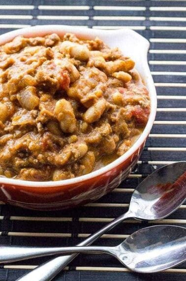 a bowl of White Bean Pumpkin Chili with 2 spoons beside it