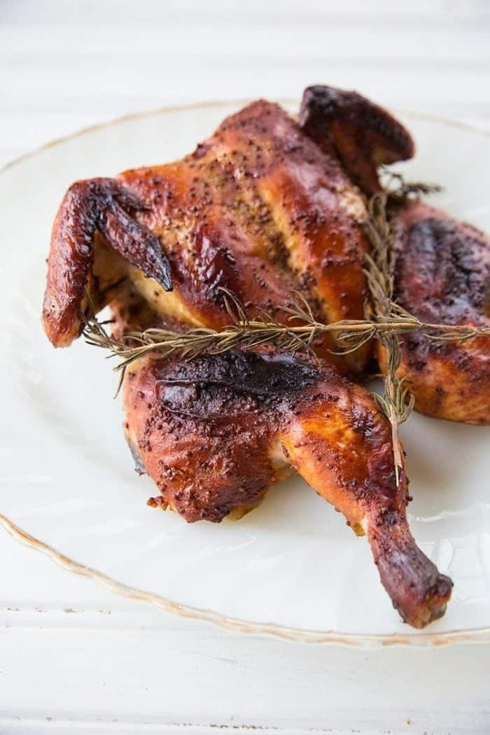 Honey Mustard Whole Chicken in White Plate with Rosemary Sprigs